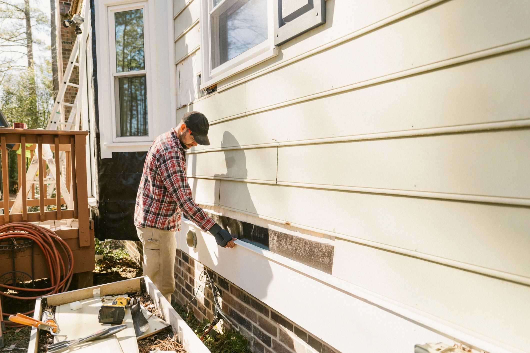 Home exterior being inspected for pest entry points